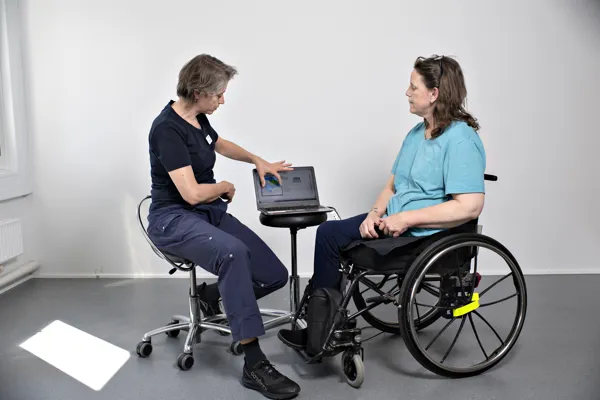 En fysioterapeut fra Specialrådgivningen rådgiver en kørestolsbruger. HandicapBilistCentret arbejder tæt sammen med Specialrådgivningen. Har en borger behov for både en ny kørestol og ny handicapbil, har vi mulighed for at samarbejde i den konkrete sag.
